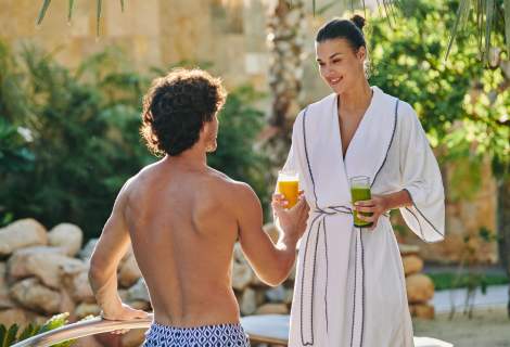 Man and women sharing smoothies by a pool