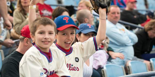 Children cheering with smiles at the baseball game