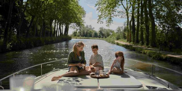 Children on top of boat enjoying breakfast.