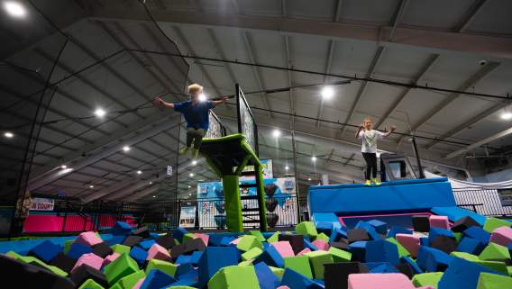 Two kids jumping into ball pit at Sky's the Limit