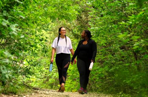 Young female friends walking on green trail