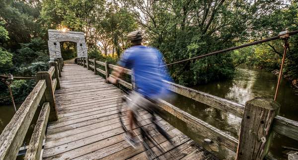 man biking over bridge in Hoyt Park