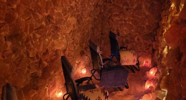 A Salt Cave with four zero-gravity chairs, dimly lit with salt lamps at Soulful Steep