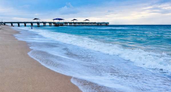Rolling waves on Pompano Beach with the Fisher Family Pier in the distance