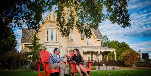 Couple drinking wine in front of a house