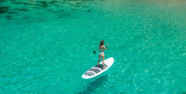 woman on paddle board on the crystal blue waters of Cocos Island in Veraguas