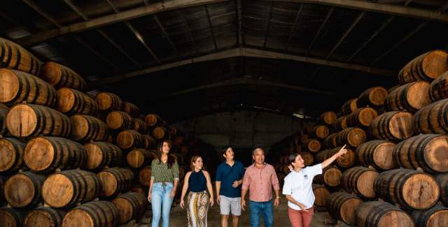 Explorers examining the contents of rum barrels in a storage area of Hacienda San Isidro, Herrera province