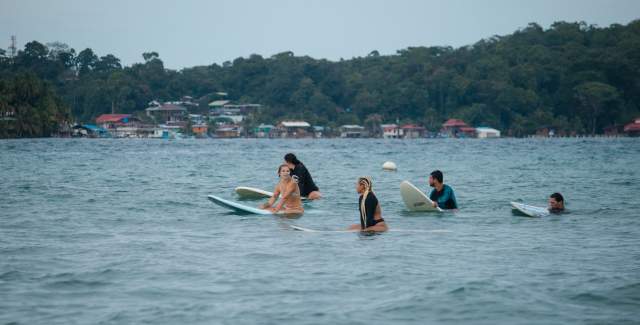 Group of surfers friends waiting for wave at Black Rock Surf, Bocas del Toro