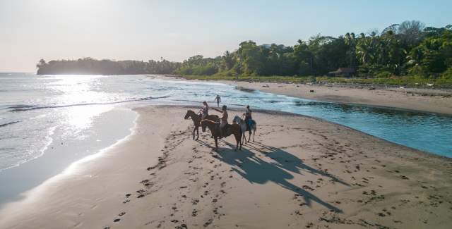 People horseback riding on a beach near Santa Catalina, Veraguas.