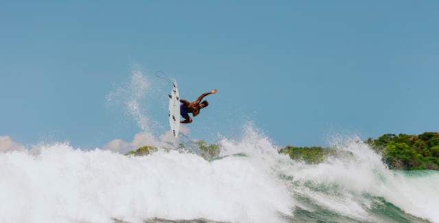 Surfer performing an aerial maneuver on the waves of Santa Catalina, a surf destination in Panama.