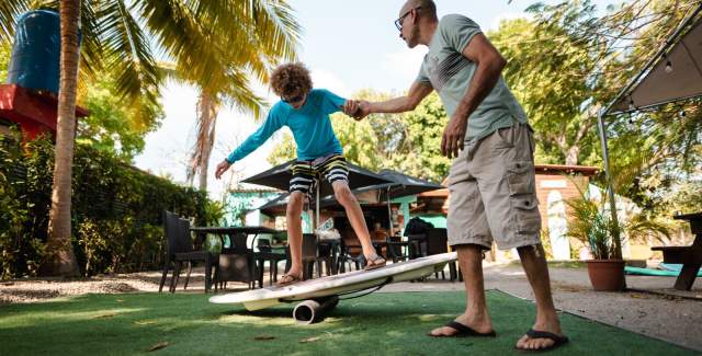 Surf teacher with a student in a paddle practicing equilibrium