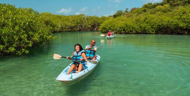 Group kayaking at Natural blue pool on a beautiful day
