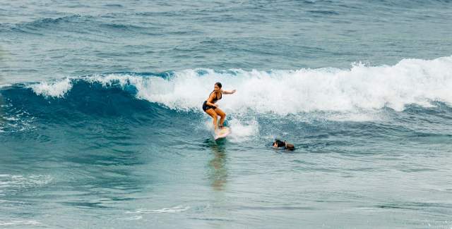 Woman riding a wave on a Caribbean Sea of Isla Colon