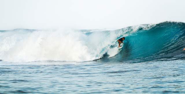 Surfer on a huge, blue and perfect wave at Bocas del Toro