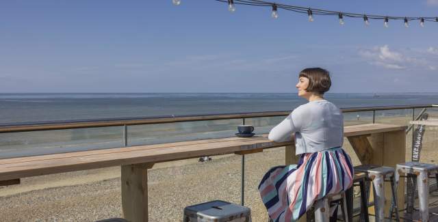 A solo traveller having coffee at The Beach Cafe in Littlehampton