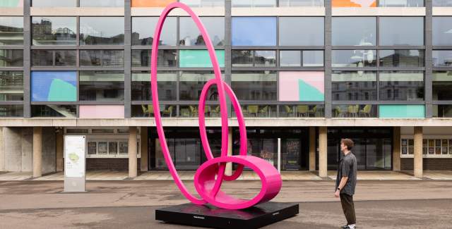 A person looking at a pink sculpture at Towner Eastbourne
