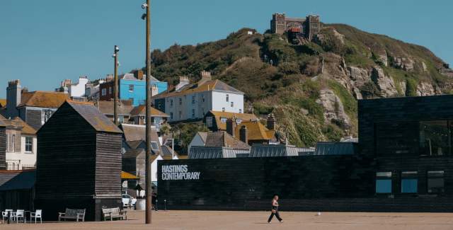 Exterior view of Hastings Contemporary with the old town and a hill in the distance