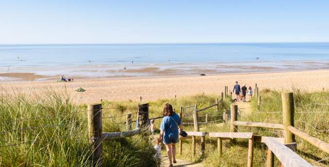 West Beach sand dunes and blue sea with people walking towards the sea on a wooden board walk