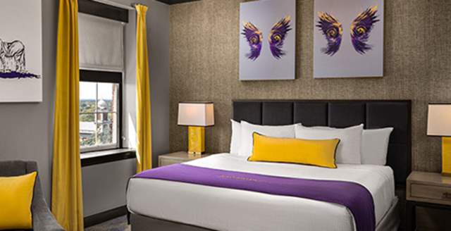 Hotel room bed, two framed artwork of wings above the bed