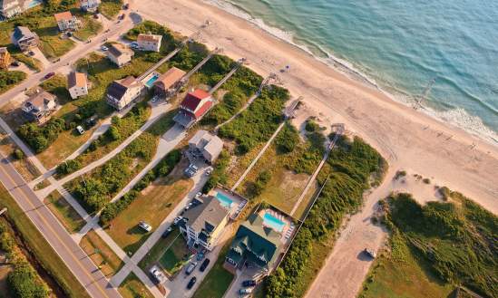 An aerial shot of beach-front rental homes situated on the coast of the Outer Banks in North Carolina.