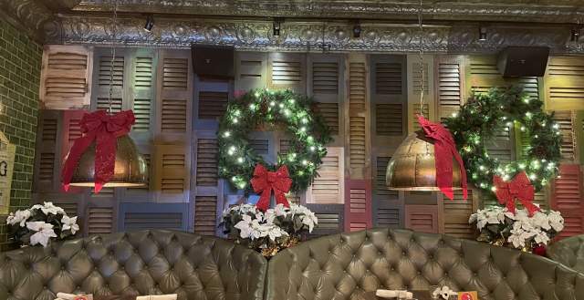 Two banquettes set for six diners and decorated for the winter holidays. Location is Big City Tavern