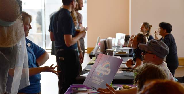 Information tables set up with a crowd of people in front of them