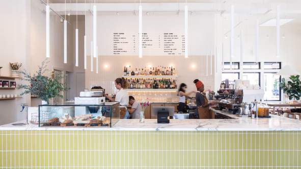 Baristas making drinks behind the marble counter at Goosecup coffee shop in downtown Leesburg Virginia