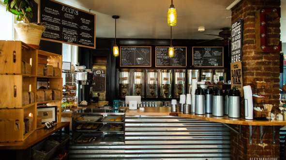 Coffee bean dispensers and chalkboard menus behind the counter at King Street Coffee in Leesburg Virginia