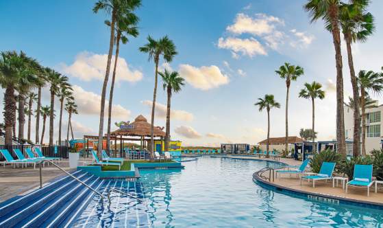 Clear blue pool with tropical setting facing the beach