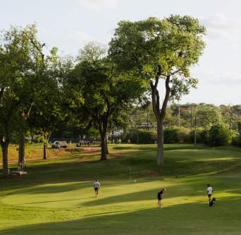 Three men playing golf at Butler Park Pitch and Putt.