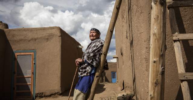 Man Leaning Against a Pole