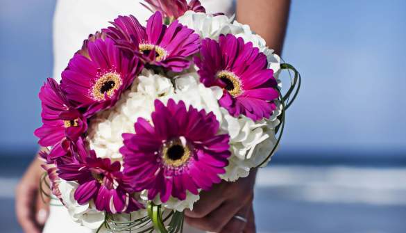 A bride holds her bouquet for a beach wedding in the Outer Banks