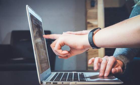 People pointing at laptop