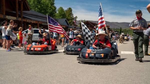 Go Karts with American Flags roll Grand Ave. in a parade