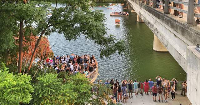 View from north side of Congress Avenue Bridge of crowd along gathering to watch the Austin bats.
