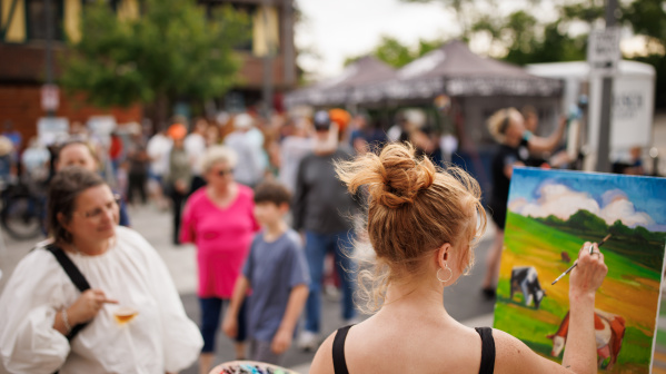 Crowd watching artist paint live at ART 64