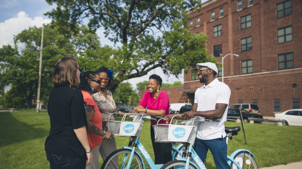 group of friends laughing around bublrr bikes