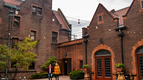 couple walking and holding hands in courtyard