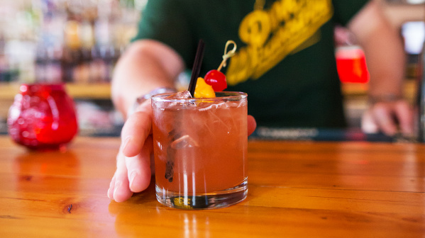 bartender offering old fashioned at bar