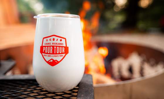 White Pour Tour Tumbler in front of campfire