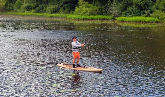 Man on paddleboard fishing in Huron River