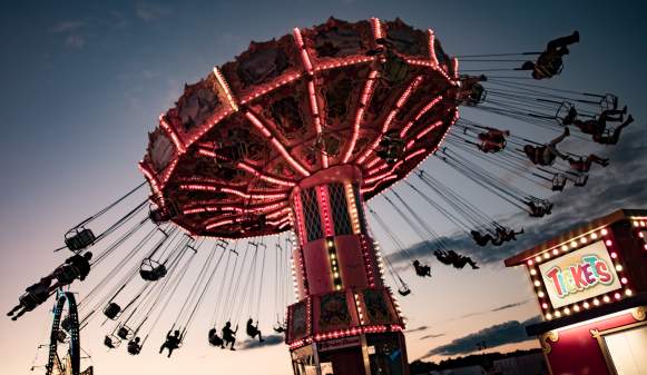 Swinging carousel with a sunset in the background and happy children laughing