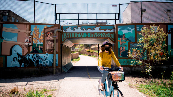 woman biking under Valley Passage Bridge