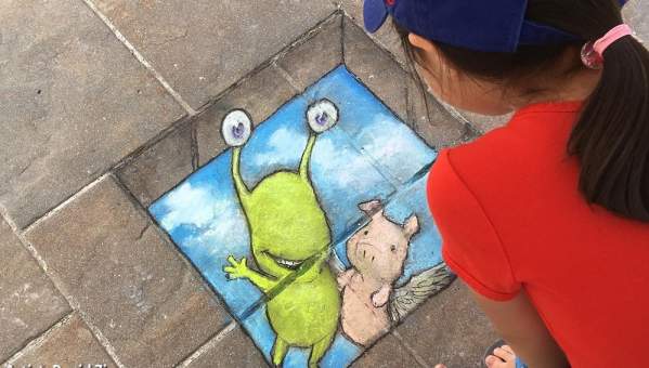 Child admires artwork by David Zinn at Ann Arbor Summerfest