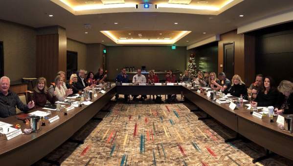 People sitting around on large tables during a board meeting