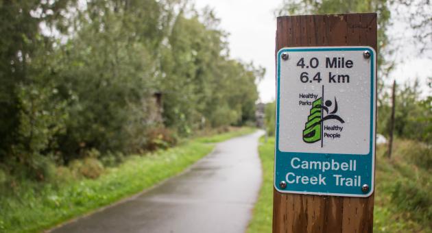 Campbell Creek trail sign with distance and trail name