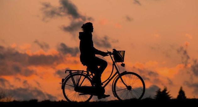 person cycling against the sun