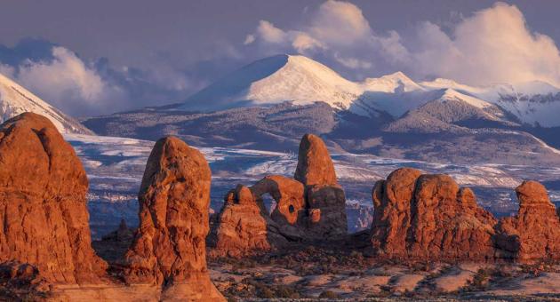 A view of The Windows section of Arches National Park, with the snow-covered La Sal Mountains in the background.