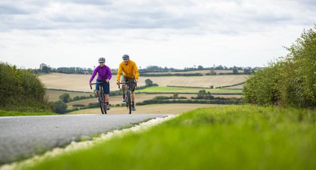 A couple cycling in the Lincolnshire Wolds, with rolling hills in the background