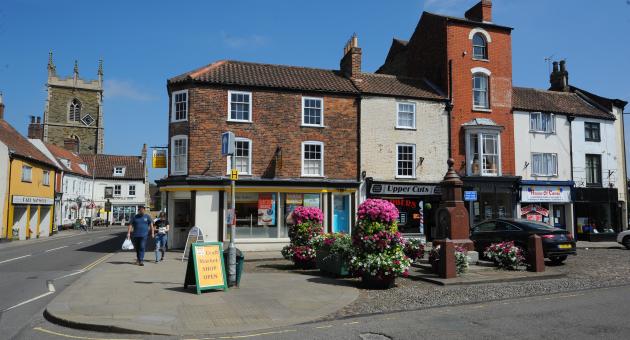 A village street with lined with shops and church in the background